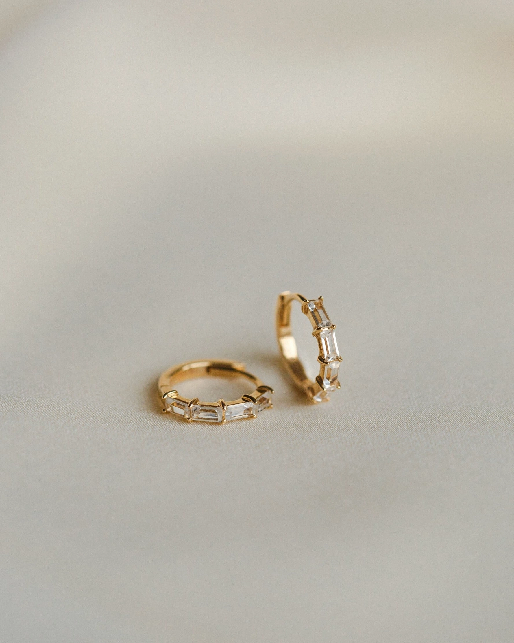 Nouveau White Sapphire Huggie Hoops Playful Spark